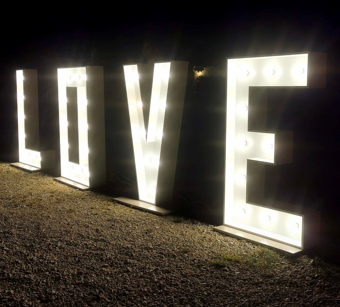 ‘LOVE’-Schriftzug aus GlĂźhbirnen Leuchtender 'LOVE'-Schriftzug aus GlĂźhbirnen bei Nacht, stimmungsvoll inszeniert auf einer Hochzeit. Begleitet von einem Hochzeits-DJ aus Aalen, der abwechslungsreiche Partymusik fĂźr alle Gäste spielt â perfekte Atmosphäre fĂźr unvergessliche Feiern.