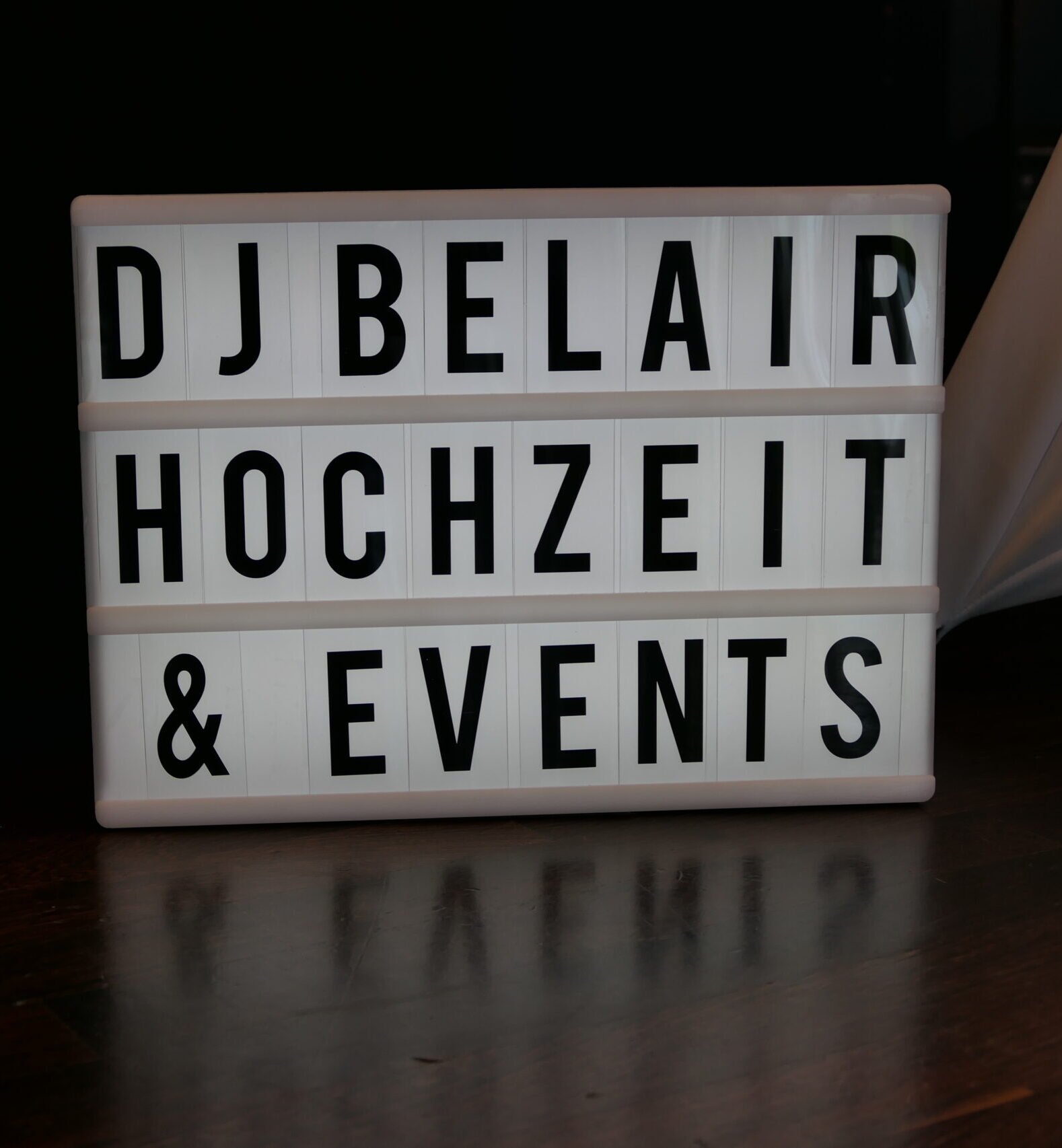 Leuchtendes Schild mit der Aufschrift 'DJ Bel Air Hochzeit & Events' auf dunklem Untergrund. Hochzeits-DJ Bel Air bietet professionelle Musikbegleitung für Hochzeiten und Events mit Partymusik, Charts und Klassikern – für perfekte Feiern in Schwäbisch Gmünd, Aalen und Stuttgart.
